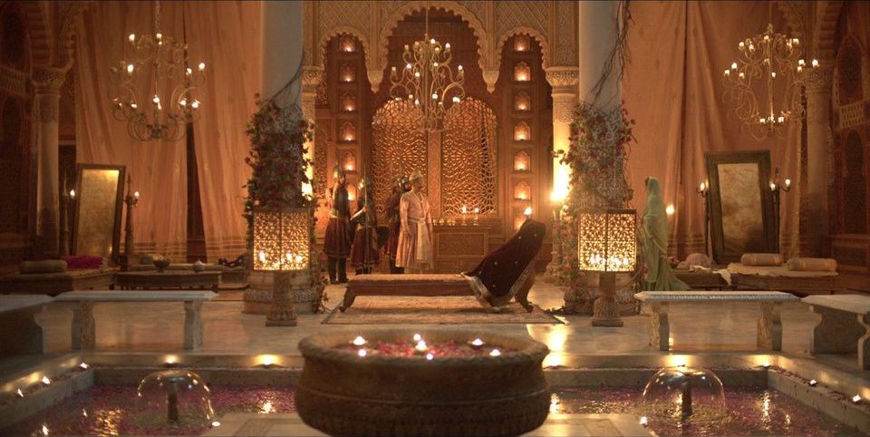 Candlelit palace chamber with a lattice doorway and a rose-petal pool, on a shooting floor at Contiloe Studio